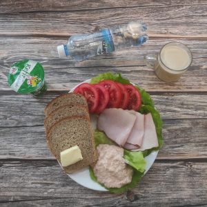 Zdjęcie przedstawia Dietę z ograniczeniem łatwoprzyswajalnych węglowodanów: Masło extra 82% Kawa zbożowa z mlekiem Chleb Graham Szynka krucha z pieca wieprzowa,parzona Pasta twarogowa pomidorowo-selerowa Kefir 1,5% Woda mineralna Sałata zielona Pomidor